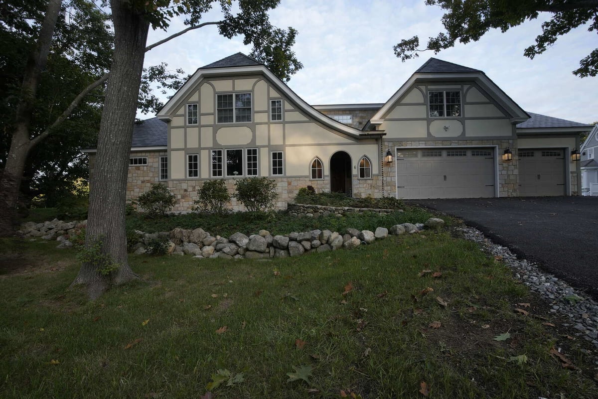 Tudor-style custom home with stone and wood accents, built by Oxland Builders in New Hampshire