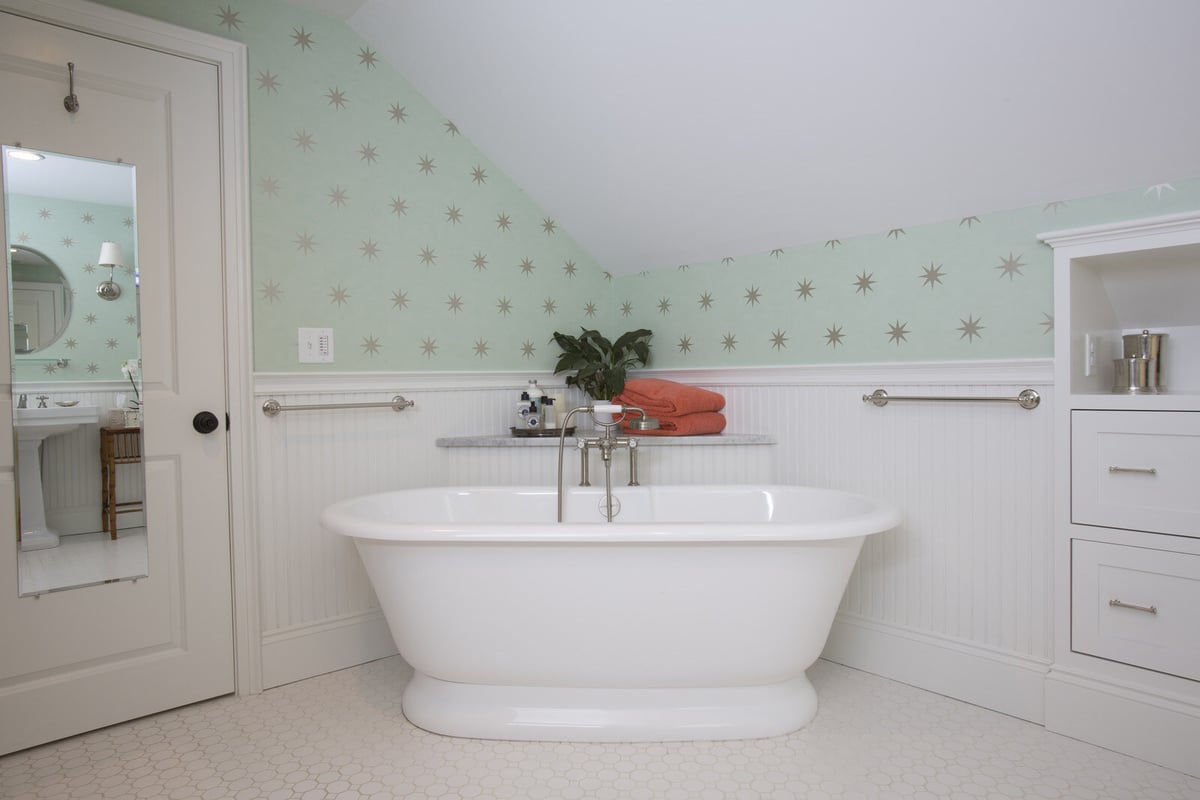Bathroom remodel by Oxland Builders in New Hampshire featuring a standalone tub and star-patterned wallpaper