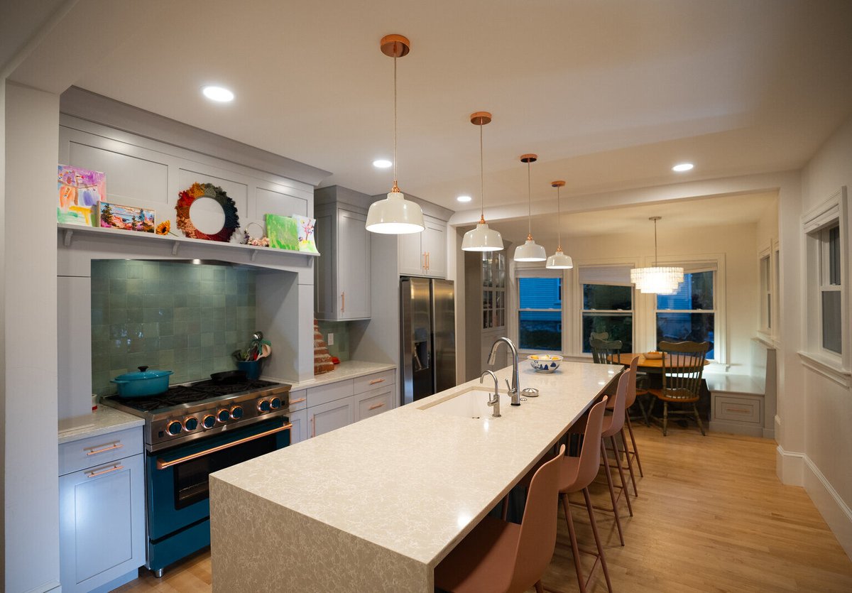 Large kitchen with an extended island and pendant lighting, remodeled by Oxland Builders in New Hampshire